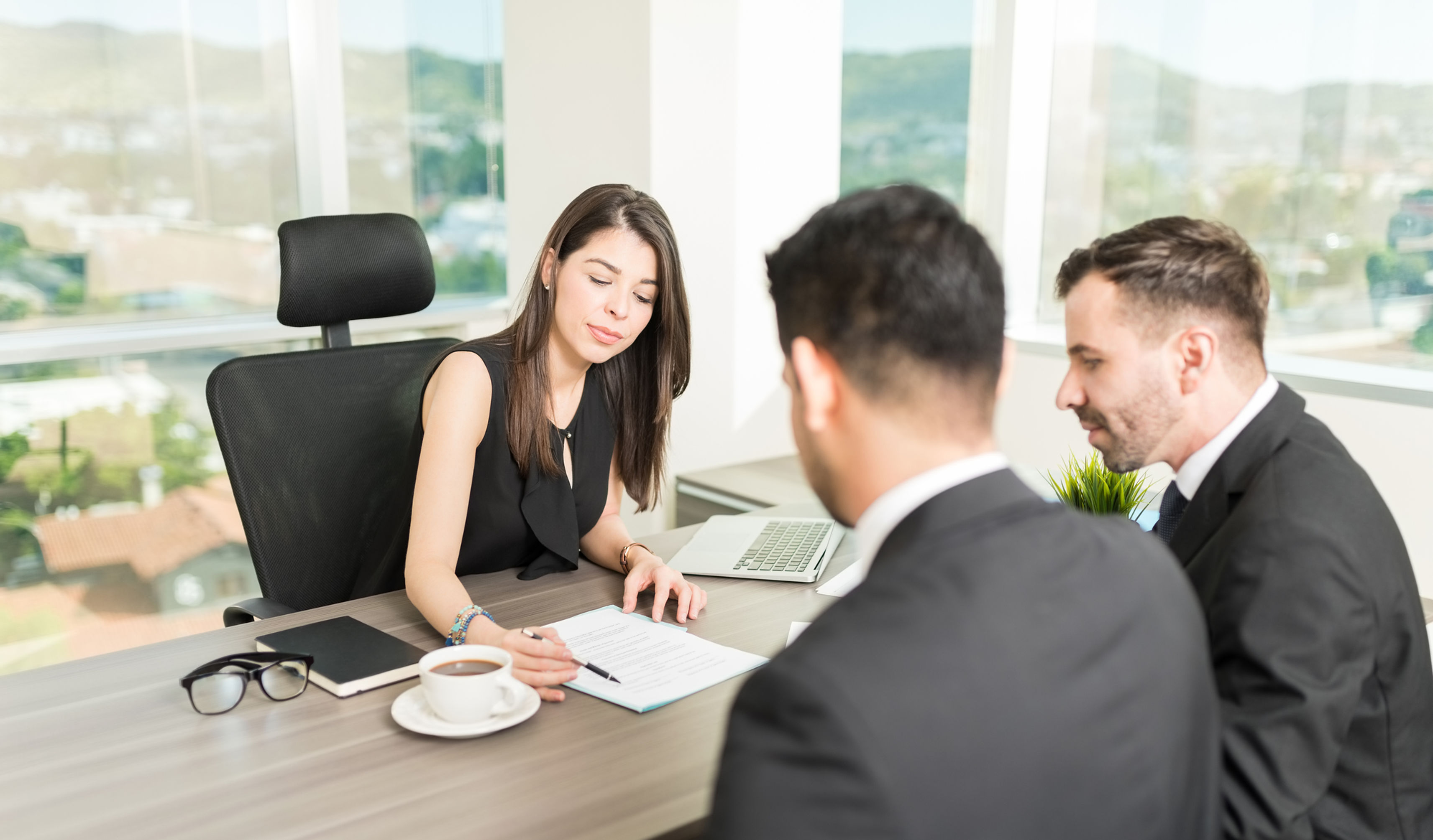 Advisor in consultation with two law firm partners reviewing a financial plan